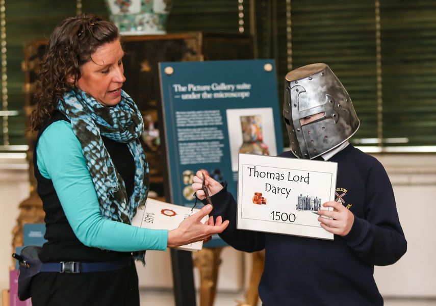 the learning officer with a child with a helmet on holding a sign