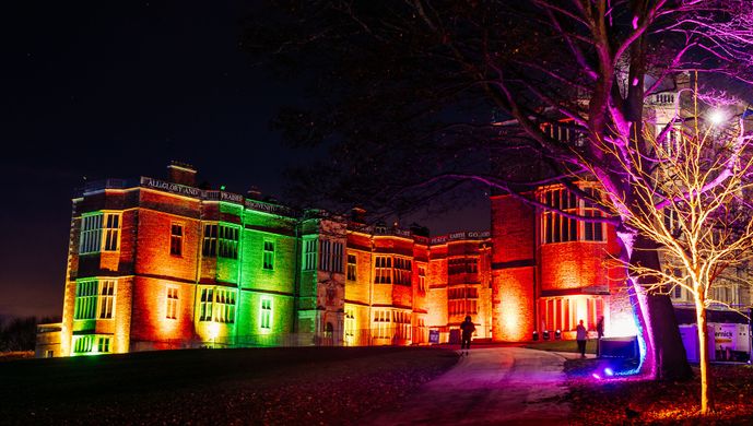Temple Newsam House illuminated by coloured lights in the evening.