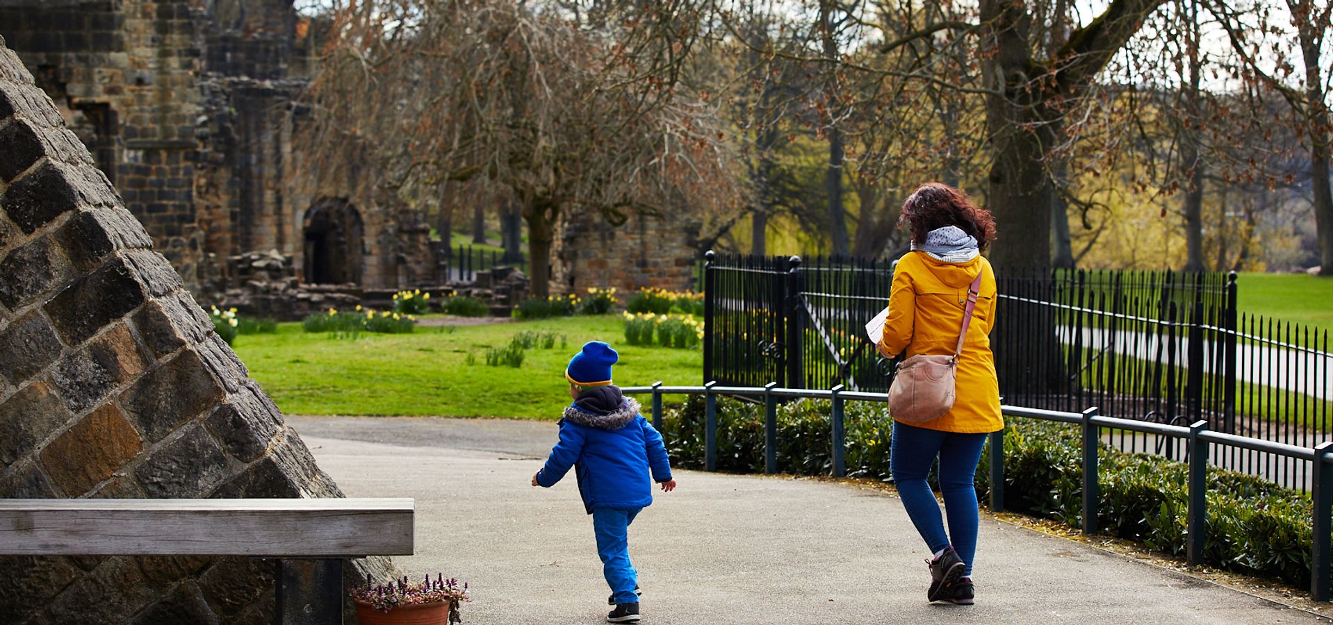 a woman walking with a child in Kirkstall Abbey