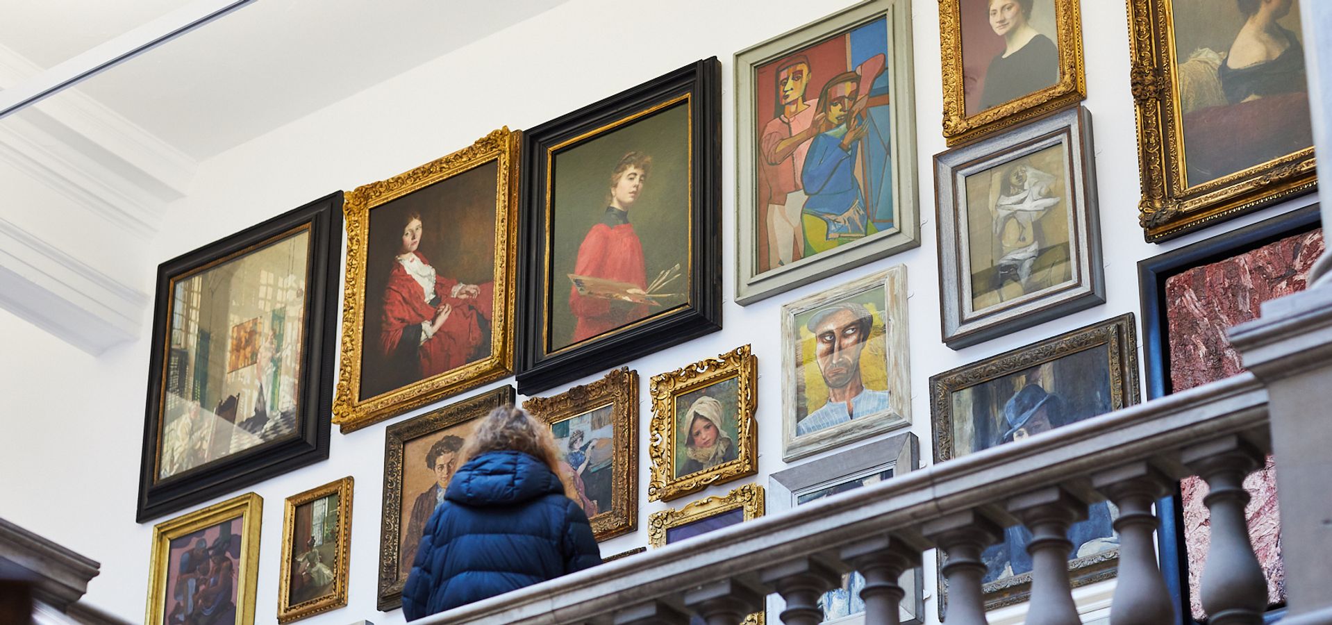 A person looking at a selection of portraits at Leeds Art Gallery