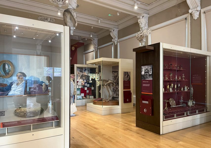 Displays from the Collectors Cabinet that feature artwork, silverware and a Moa skeleton.