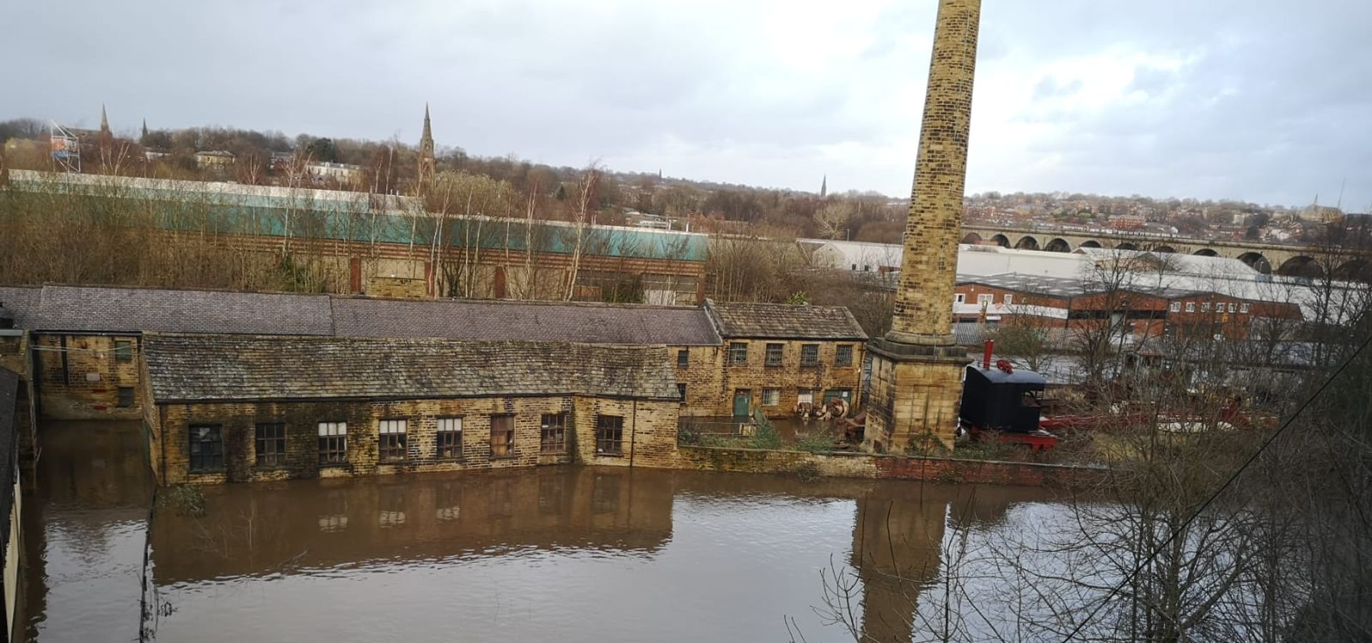 An aerial image of Leeds Industrial Museum surrounded by flood water, covering the bottom two floors.