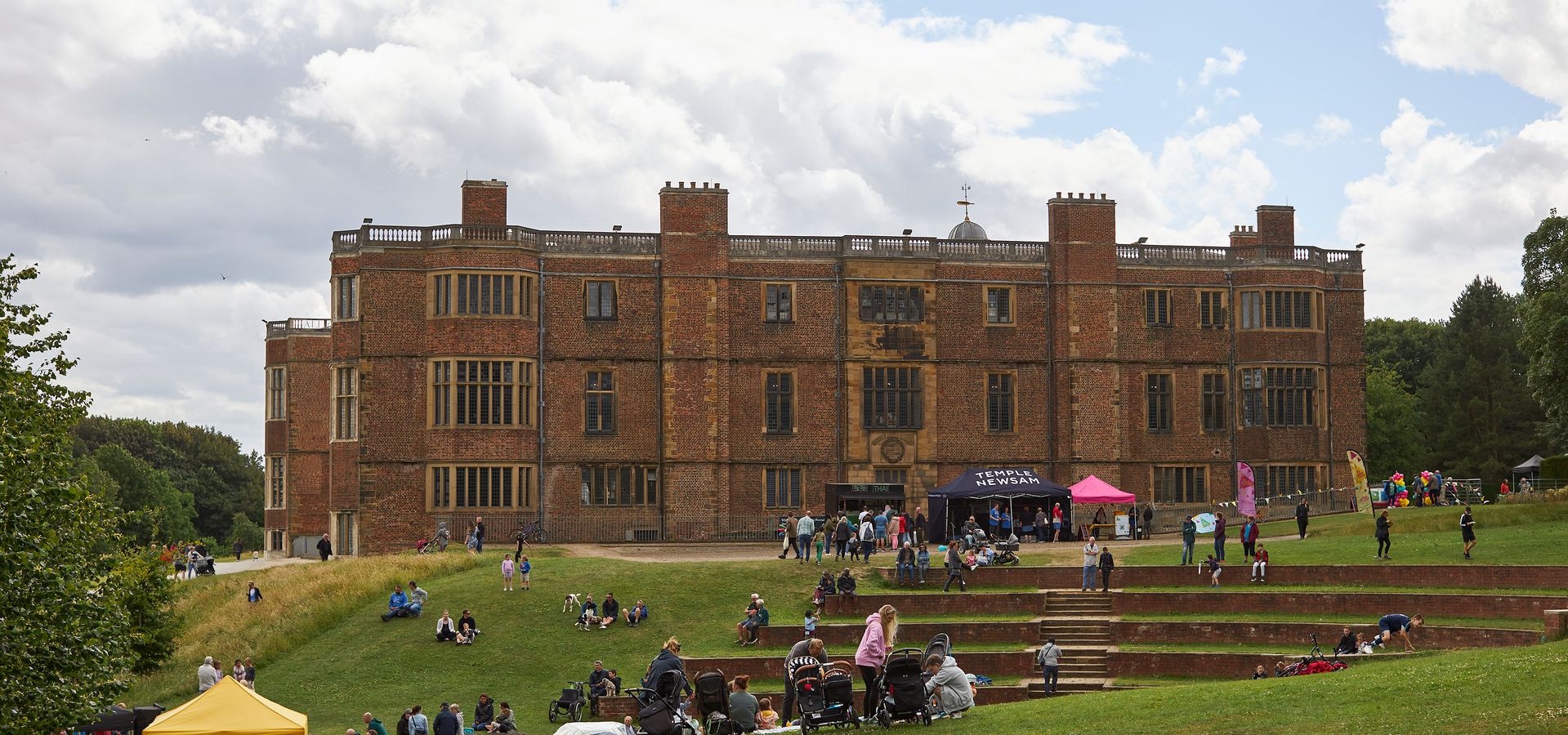 An exterior shot of Temple Newsam with people walking outside.