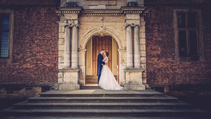 A wedding couple on the steps of Temple Newsam
