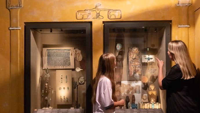 An adult and child looking at Egyptian artefacts