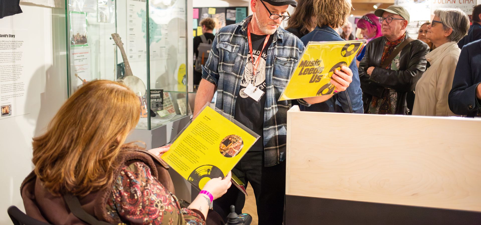 Two adults looking at records in the Music Leeds Us exhibition