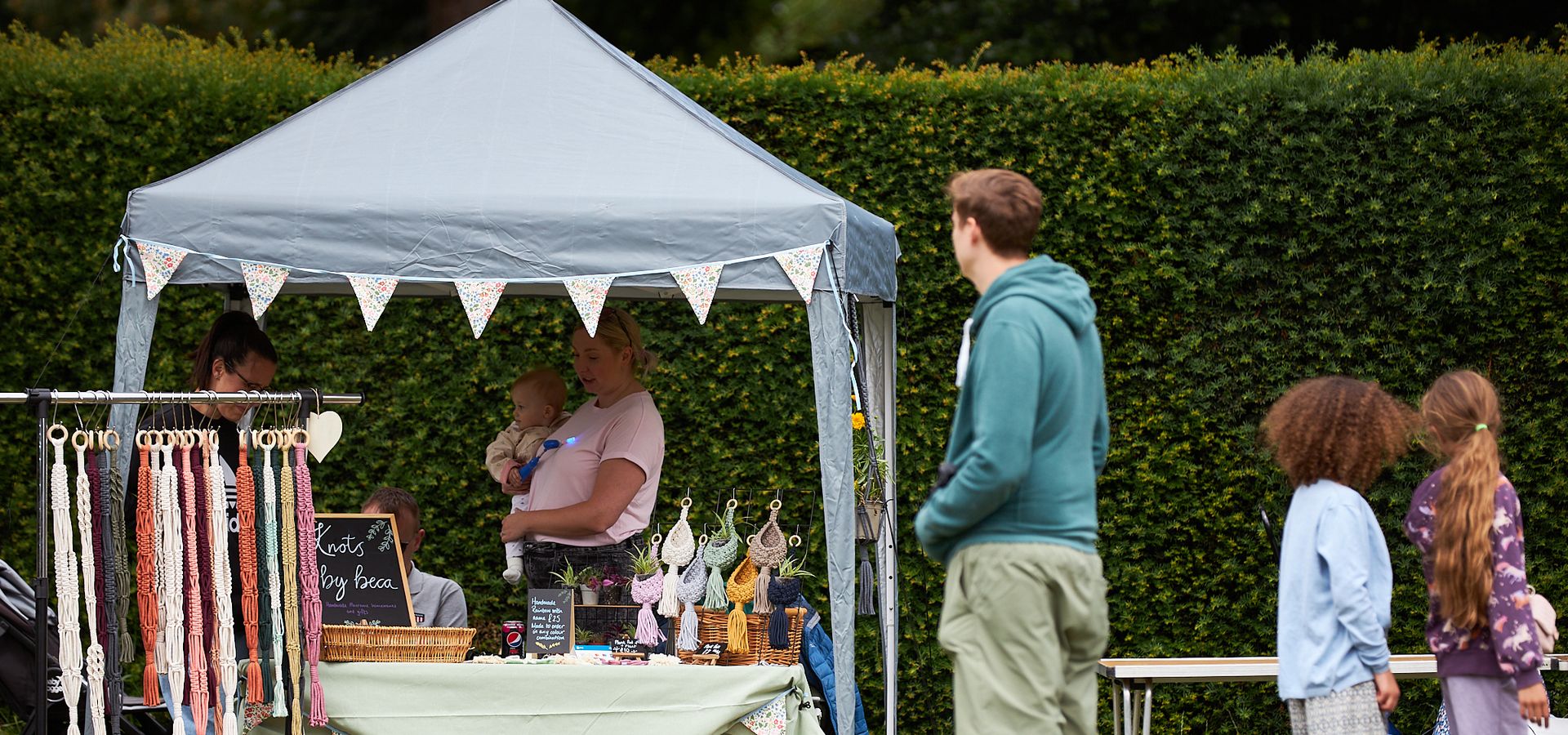 Family at an artisan fair looking at a craft stall