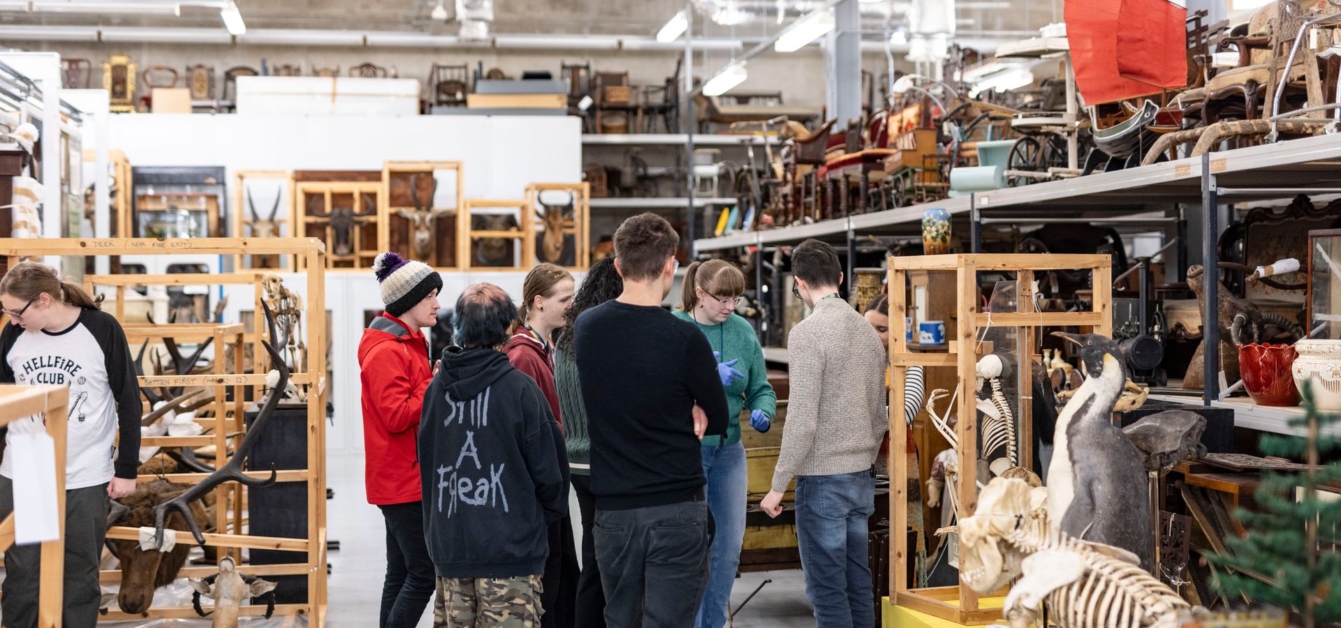 a group of young curators looking at objects in the collection store at Leeds Discovery Centre