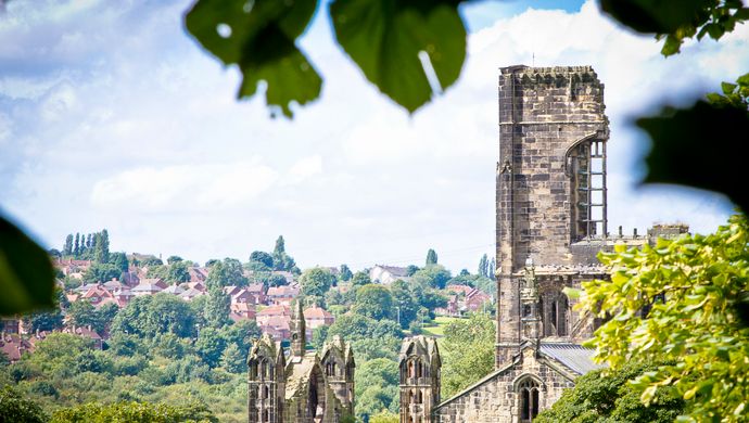 The top of Kirkstall Abbey peaking through trees