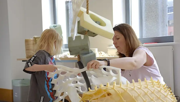 an adult and child building a sculpture