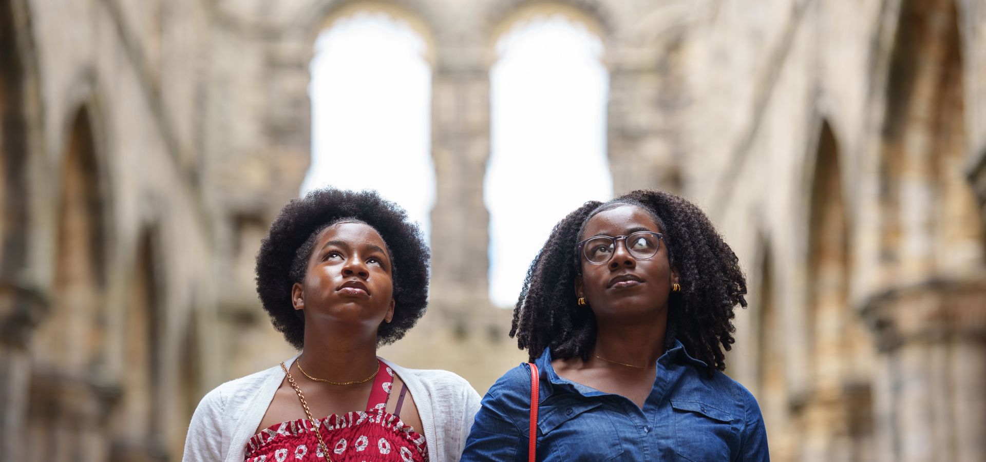 Two women looking up at the ruins of Kirkstall Abbey