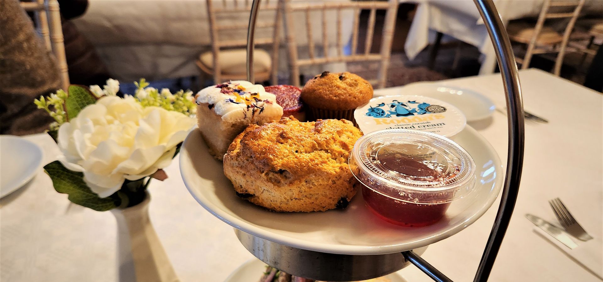 An afternoon tea stand with scones and jam on top