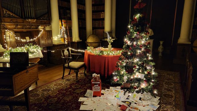 A room with light up christmas trees and lights in with letters on the floor