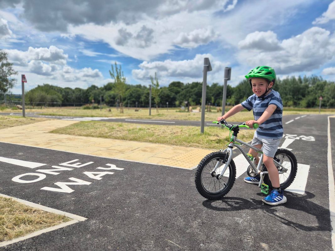 A young boy on a bike with a helmet on at Temple Newsam's new learn to ride park