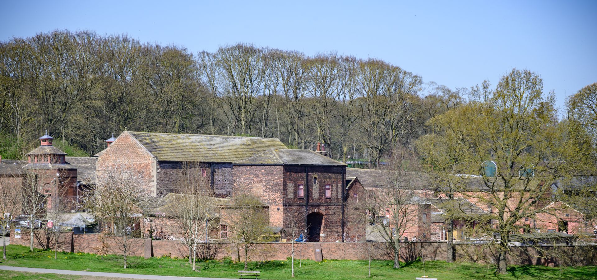Image of Temple Newsam Home Farm and people sat on the grass infront
