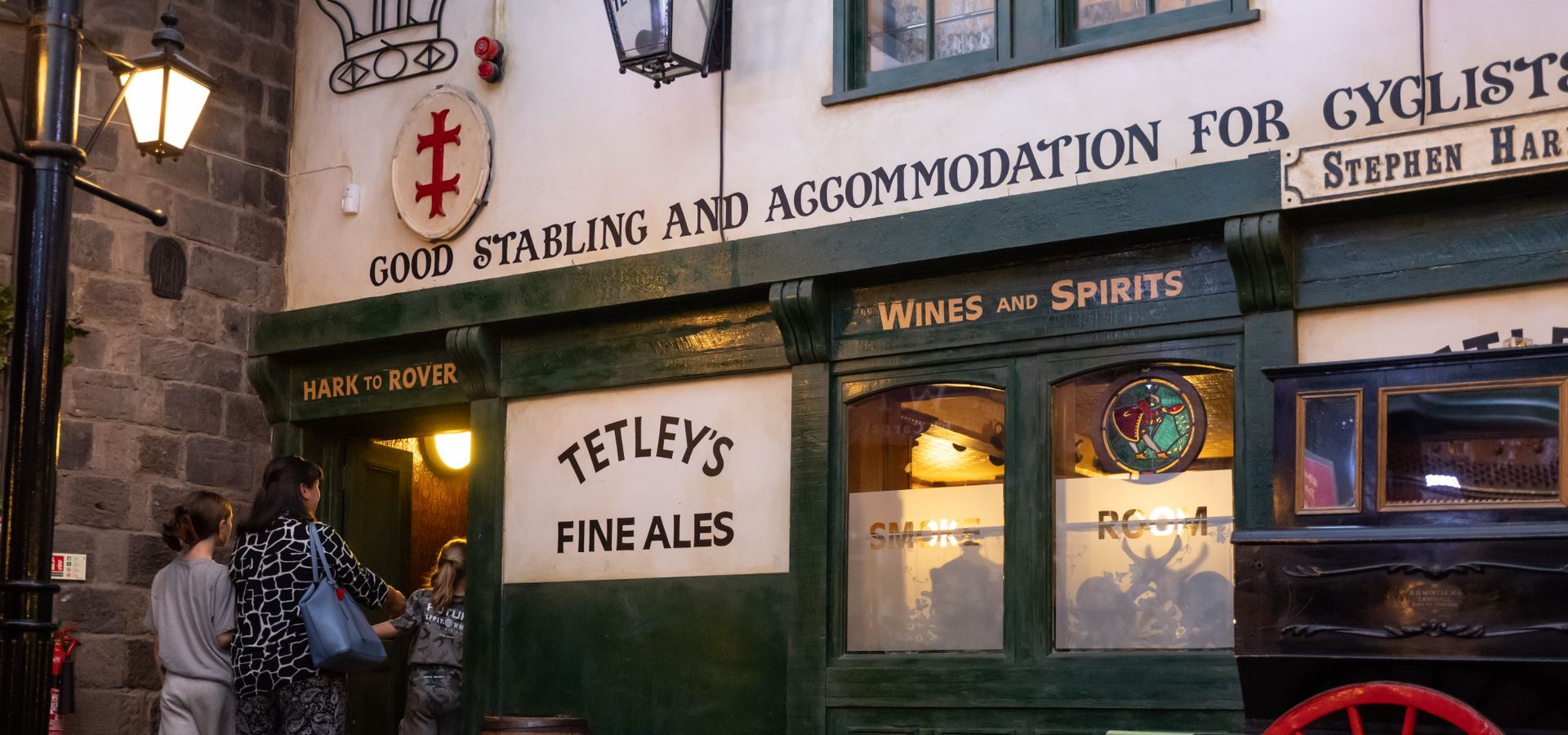 An adult and 2 children walking into a victorian pub