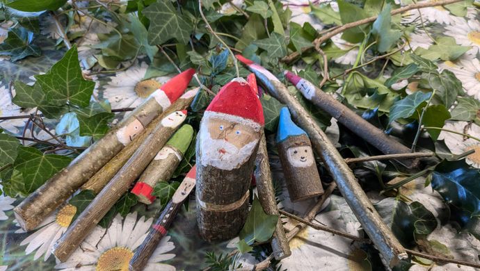 Santa decorations made from sticks on a pile of sticks