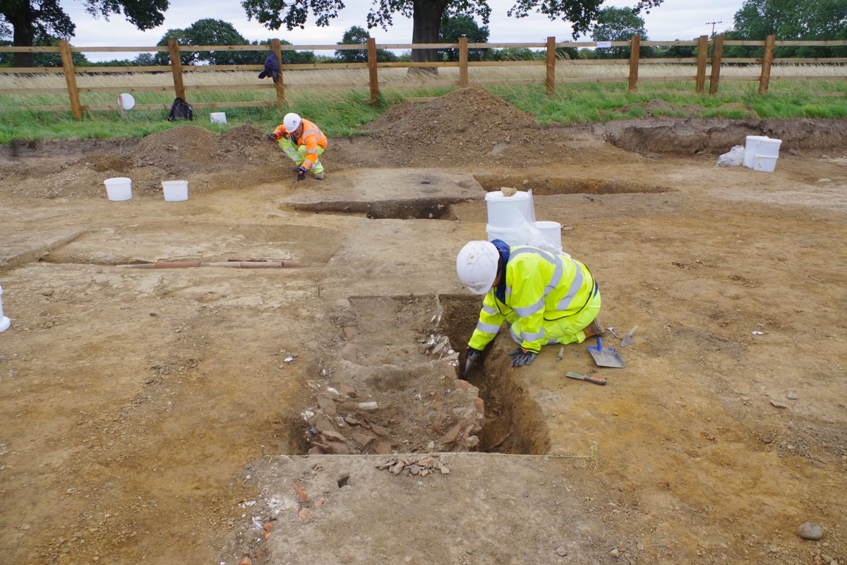 Archaeologists excavate a drainage ditch with backfill of discarded late 18th to 19th century ‘rubbish’ items like broken pieces of ceramic or porcelain, animal bone, oyster shell, glass and fragments of building material.