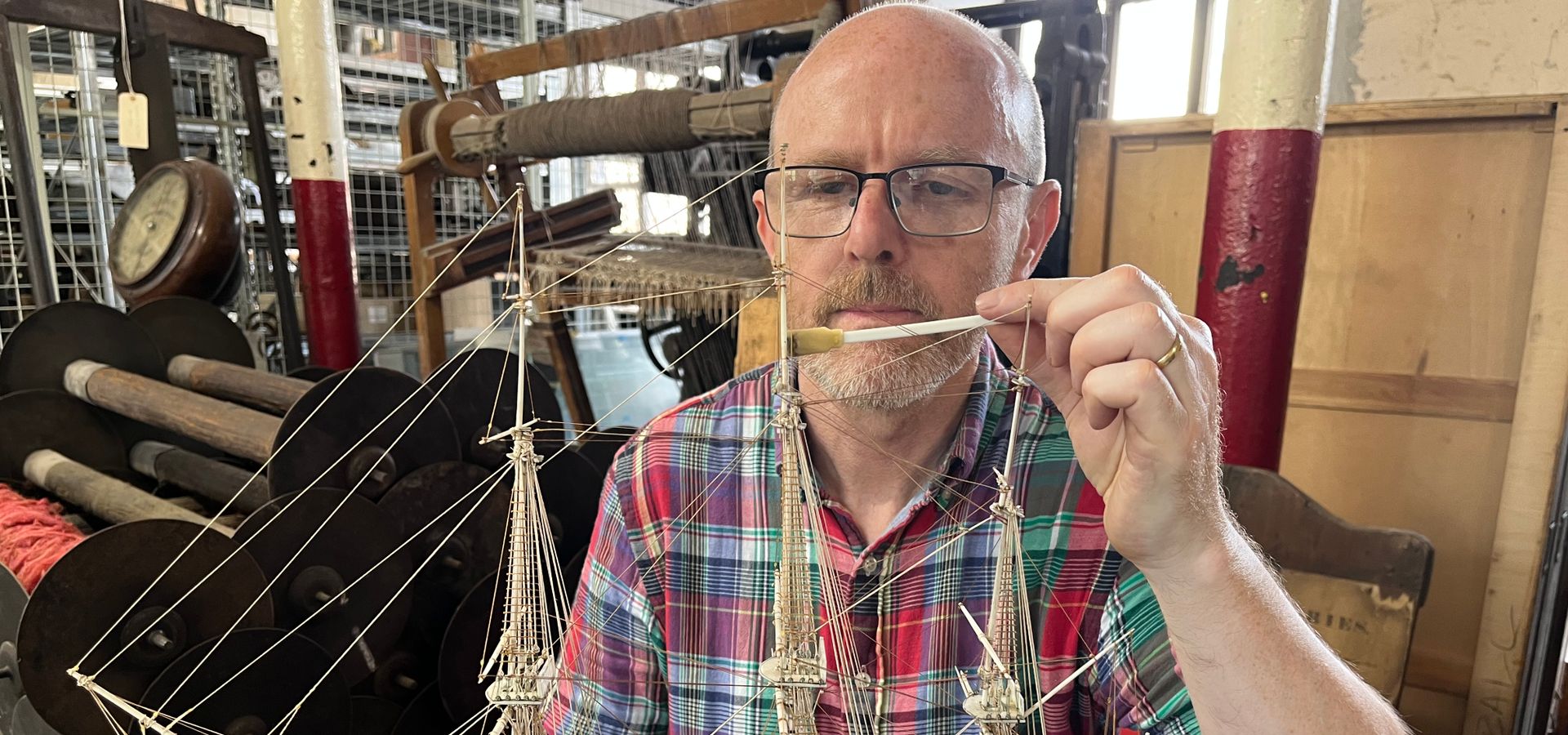 Photograph of model ship being carefully cleaned