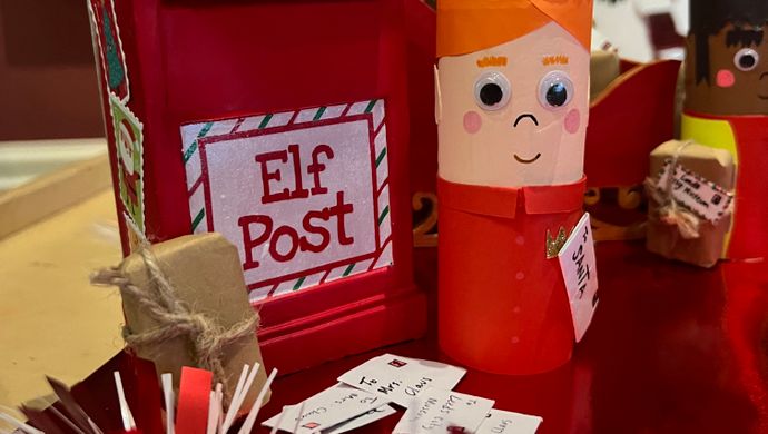 A crafted elf stood with an elf postbox