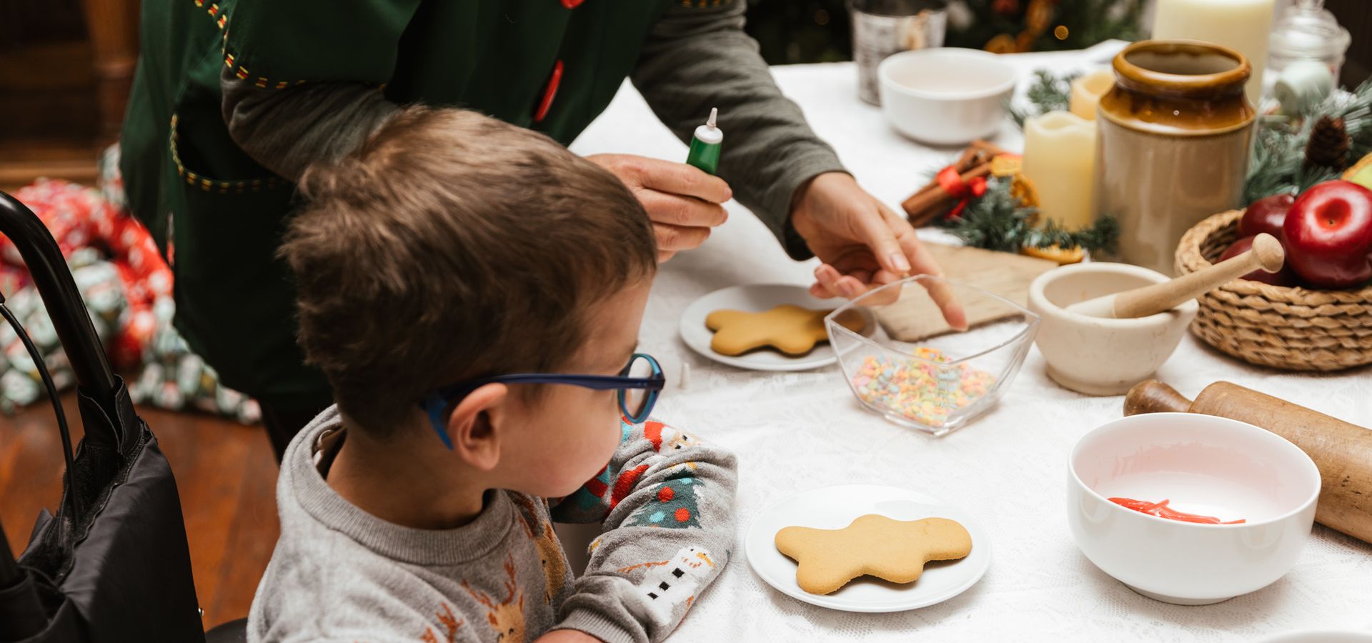 Child icing Christmas biscuits with an Elf at Temple Newsam