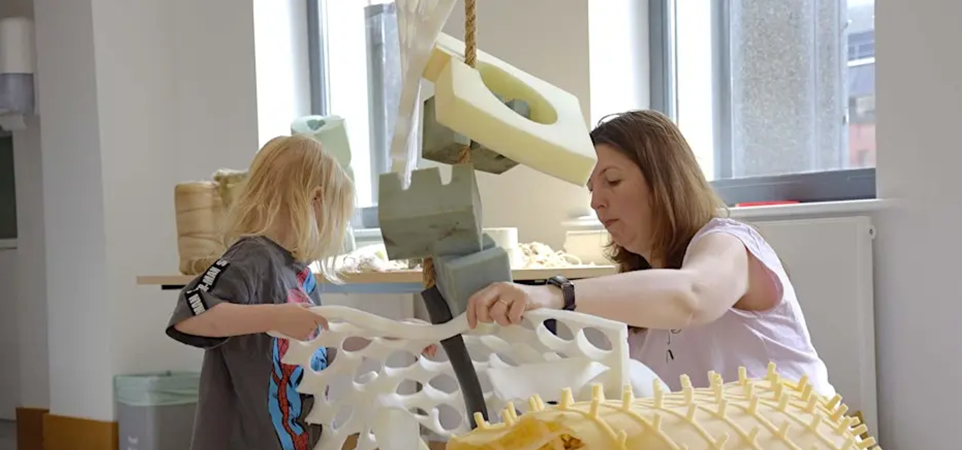 an adult and child building a sculpture