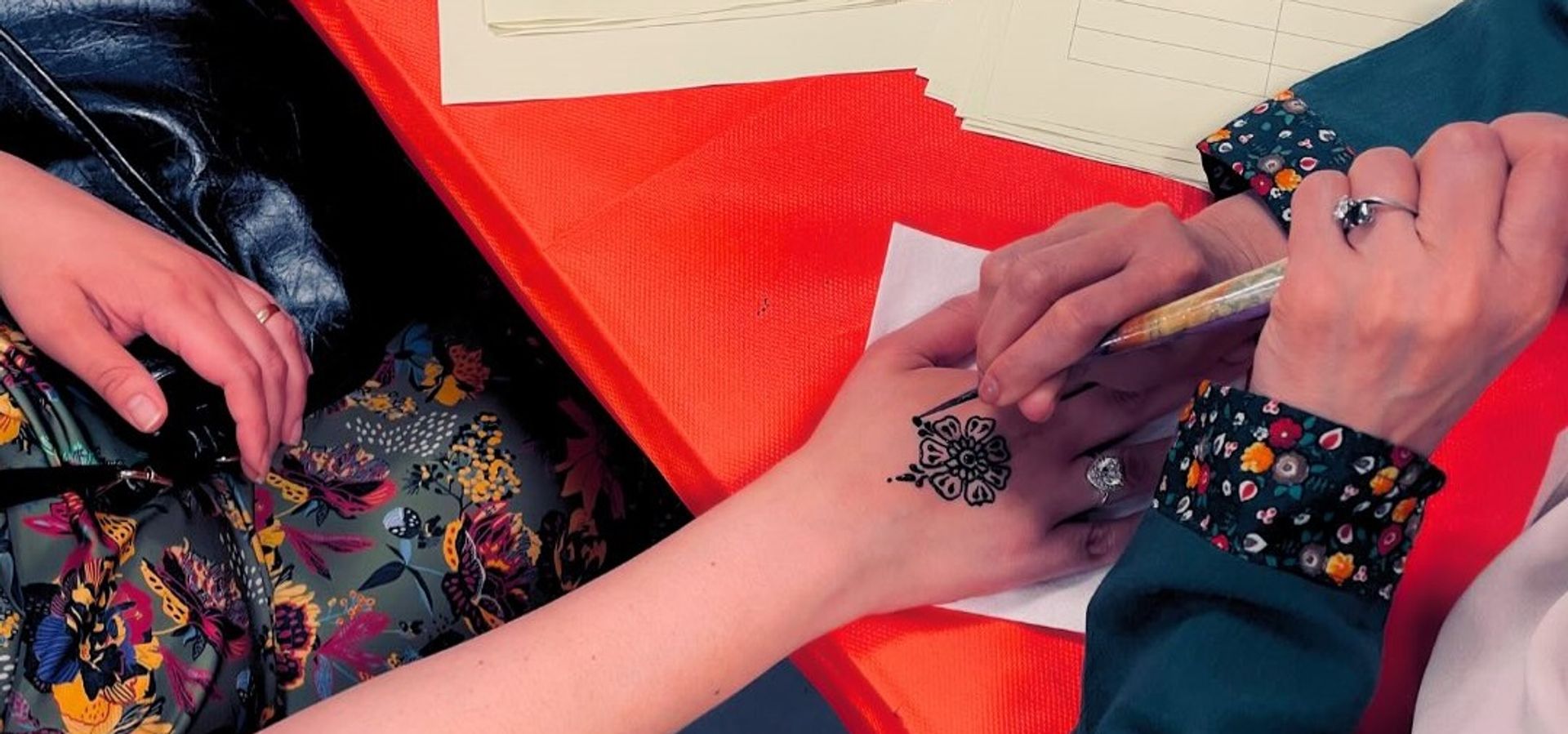 Someone painting henna onto another persons hand.
