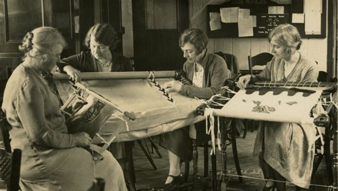 A black and white image of a group of women sewing and stitching