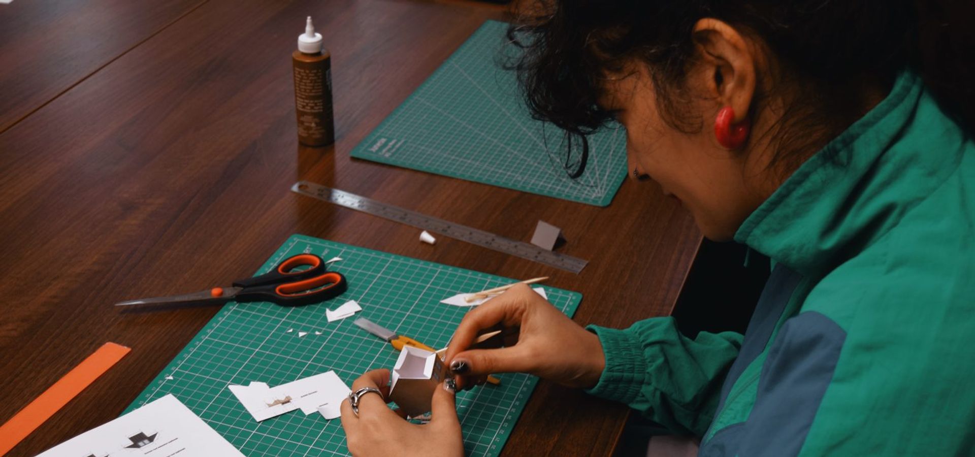 A adult working on paper crafts on a table