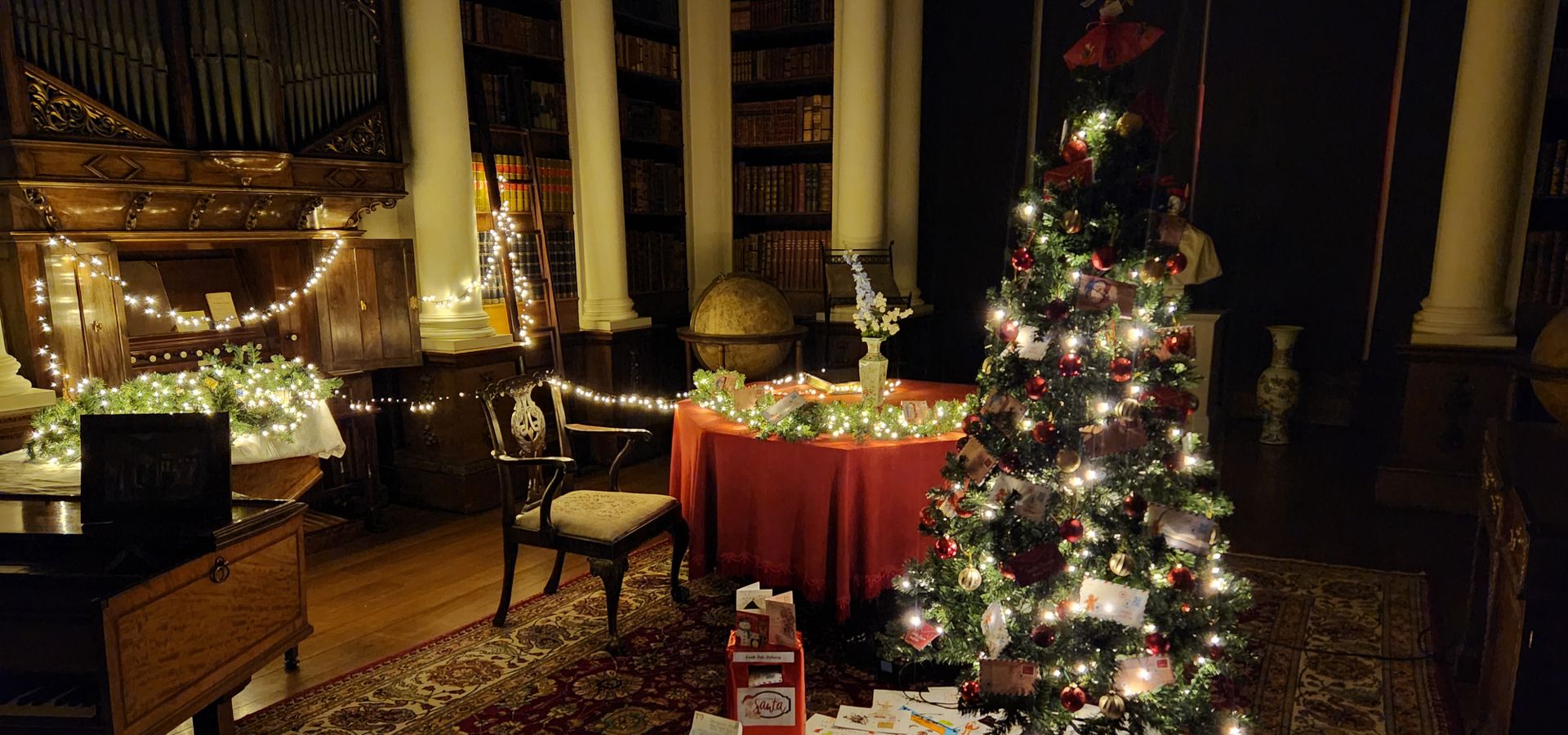 A room with light up christmas trees and lights in with letters on the floor