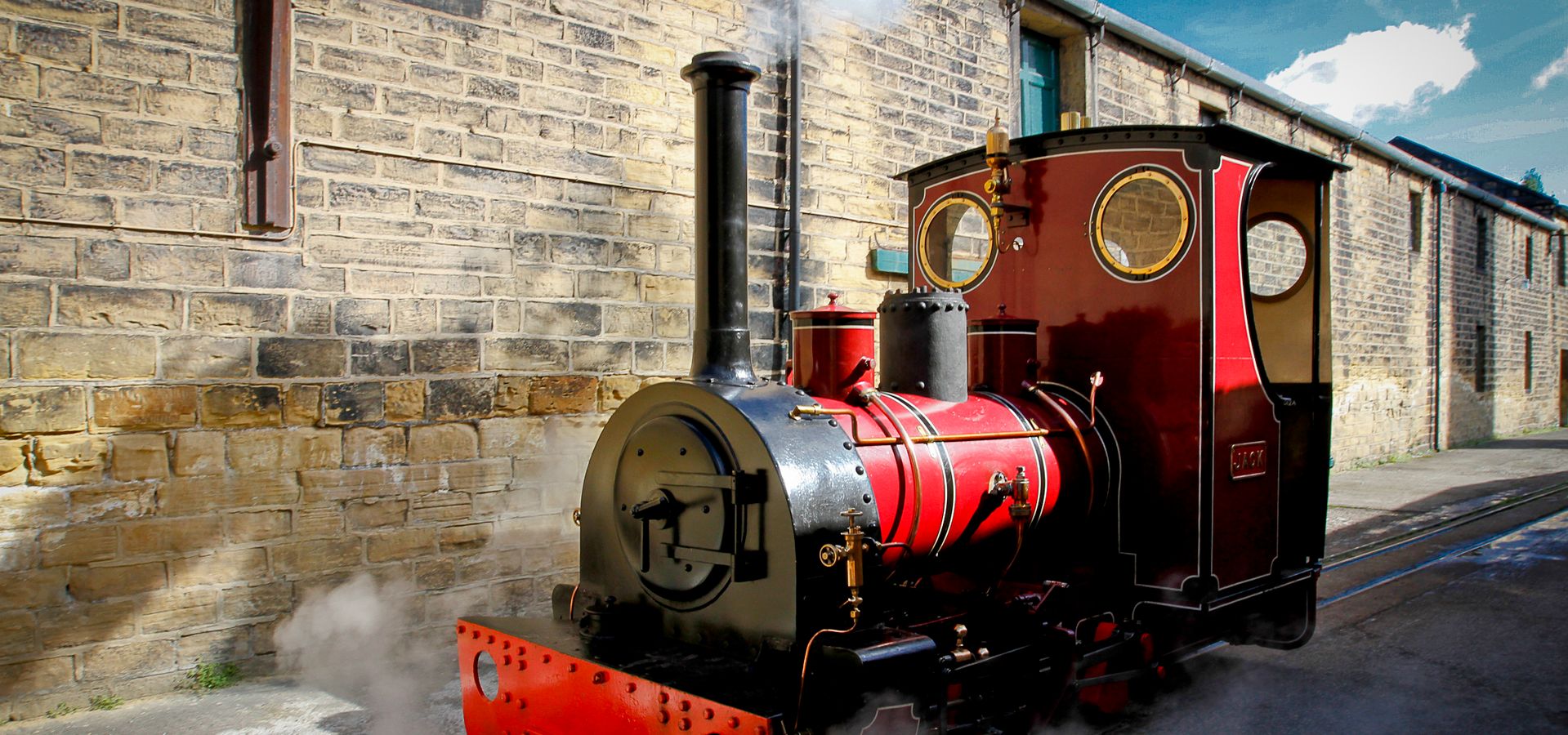 a red and black steam train called Jack outside the locomotive shed at Leeds Industrial Museum