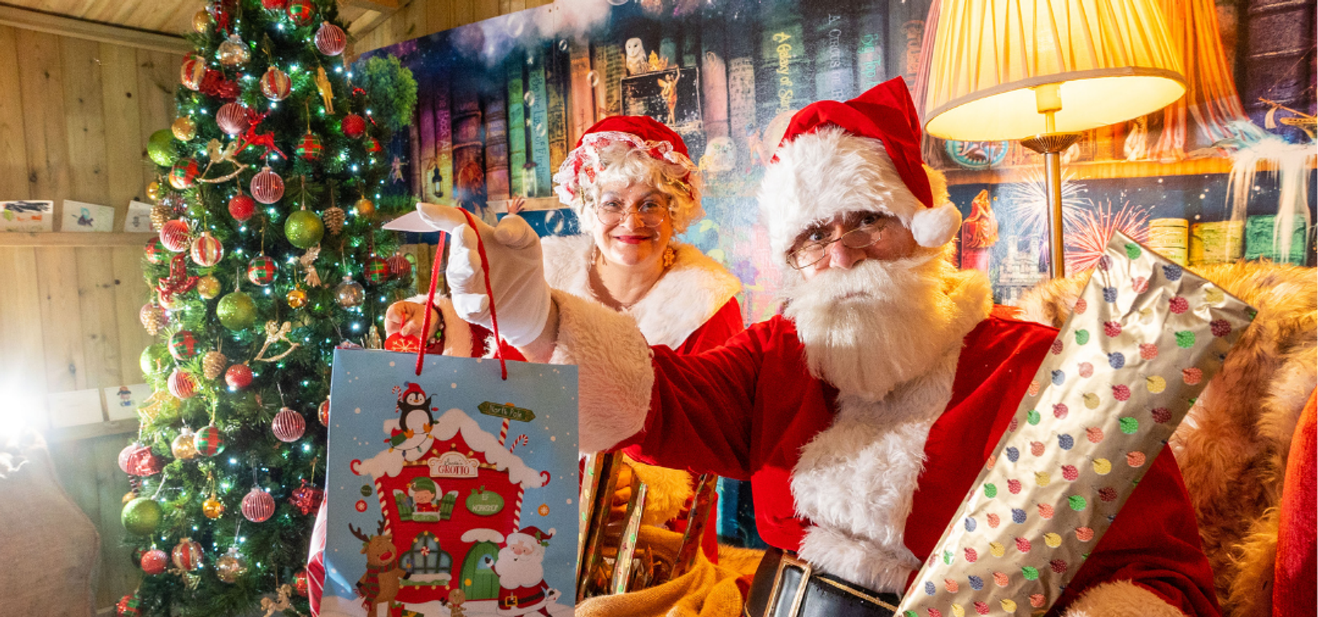 Santa and Mrs Claus holding a gift bag