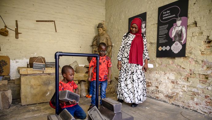 Two children and one adult exploring with machinery at Temple Newsam Home Farm