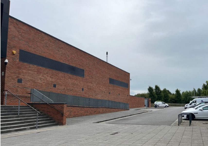 A ramp at the side of the stairs and a car park