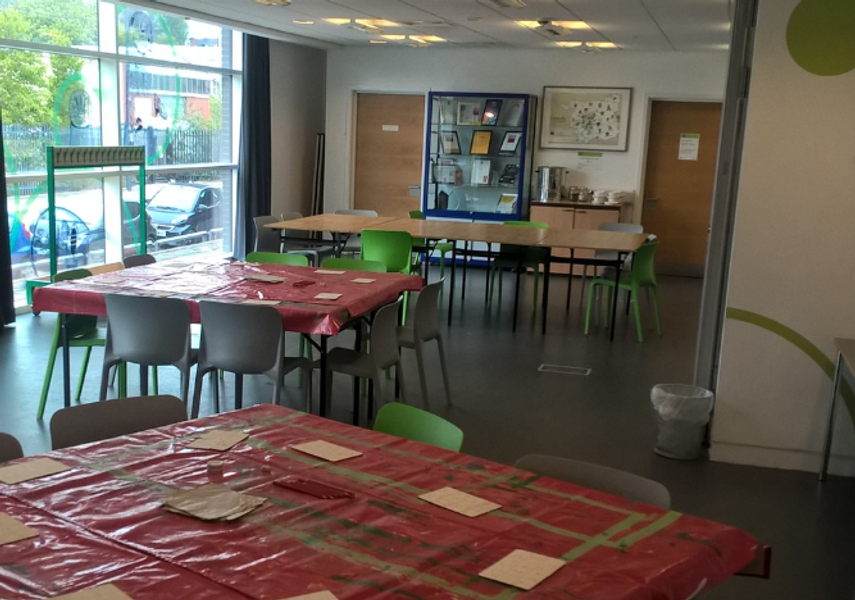 The Education Space in Leeds Discovery Centre with square tables and red table cloths and an activity set up