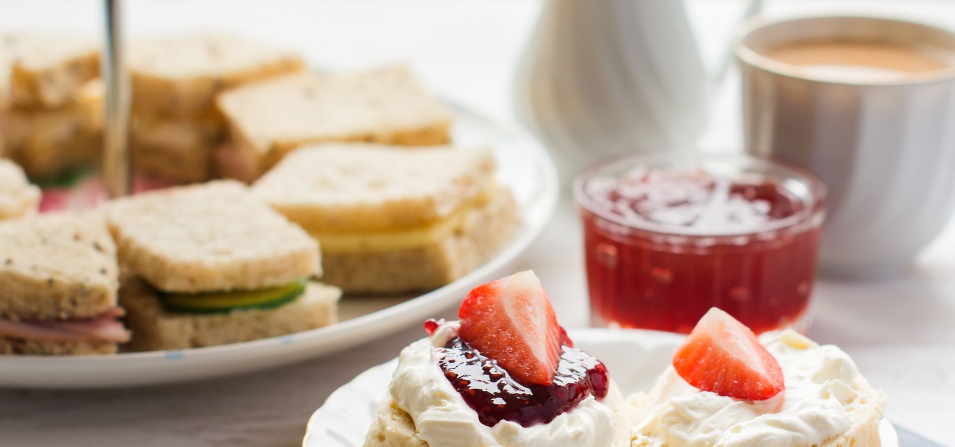 A scone with afternoon tea sandwiches behind