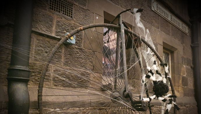 An old fasioned bike with a large spider on