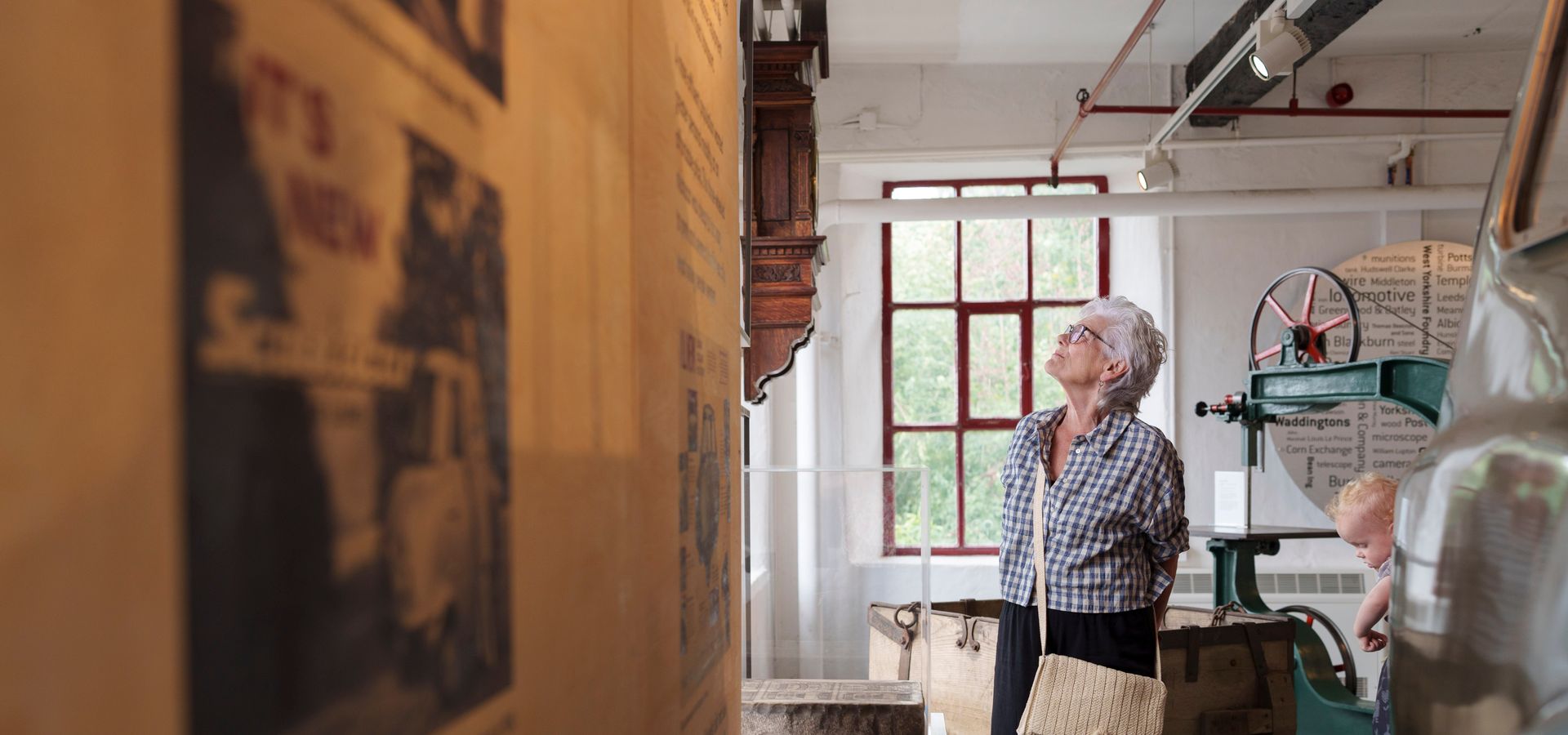 a woman looking at a wall display with objects surrounding