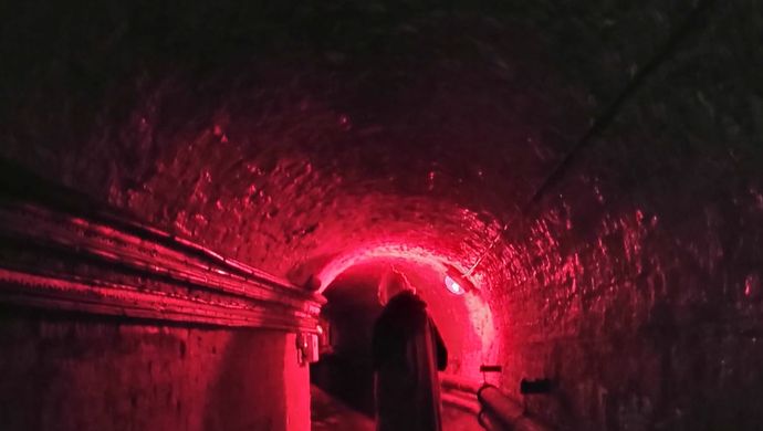 Someone walking through the dark cellars of Temple Newsam