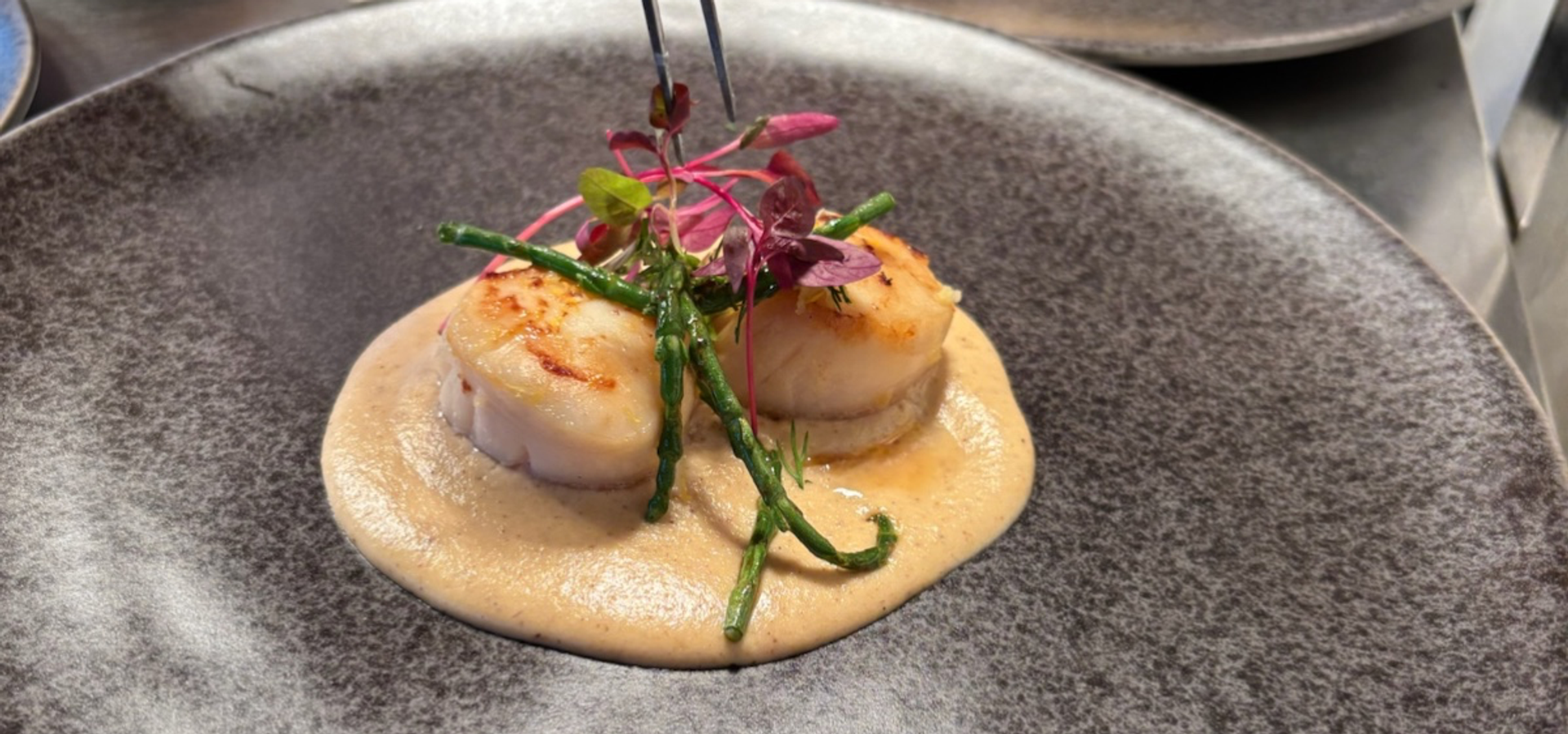 A grey plate with fine dining food