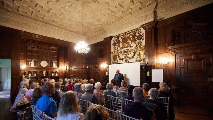 A man talking to a room full of people in Temple Newsam