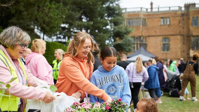 An adult and 2 children buying plants from a stall