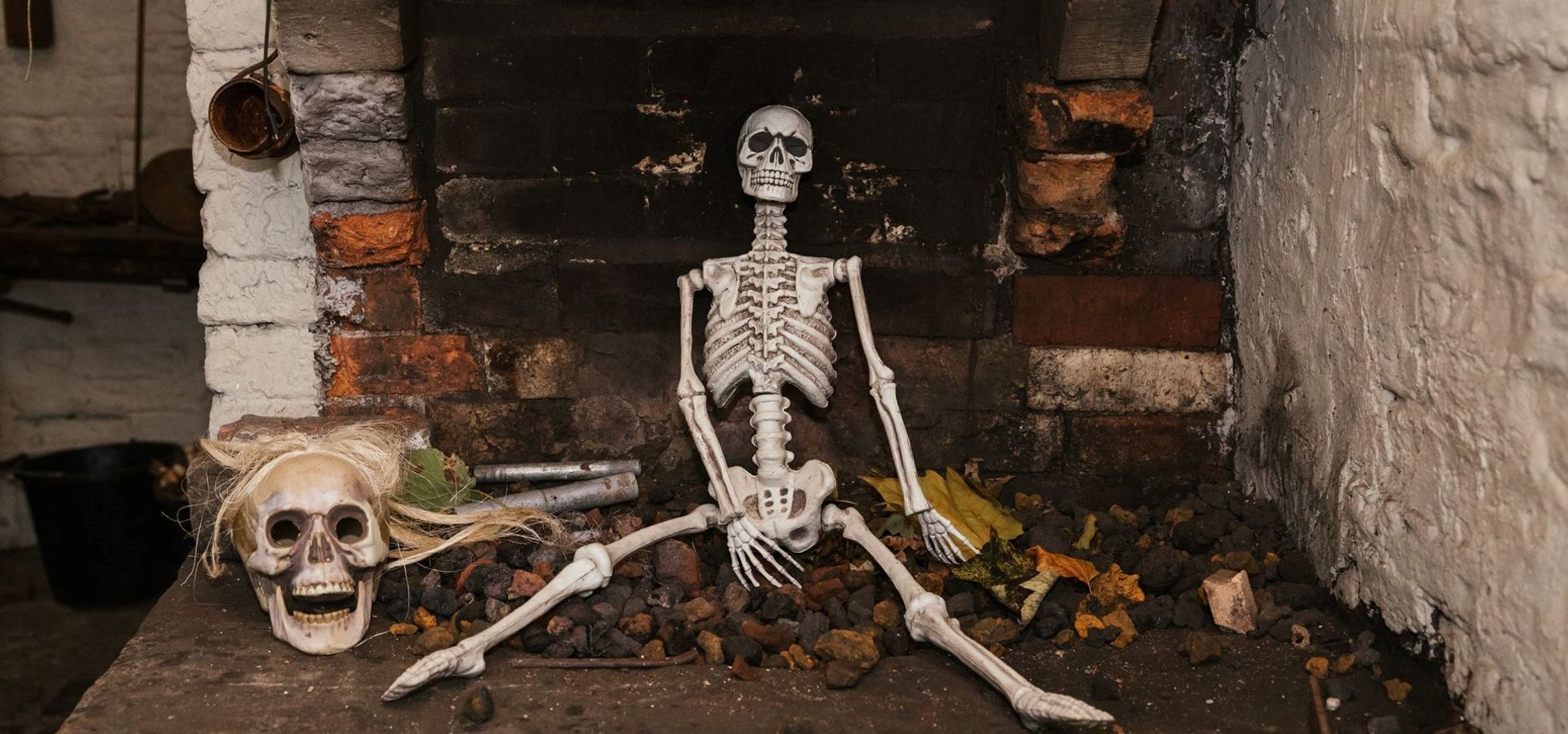 Skeleton sat in front of a fireplace