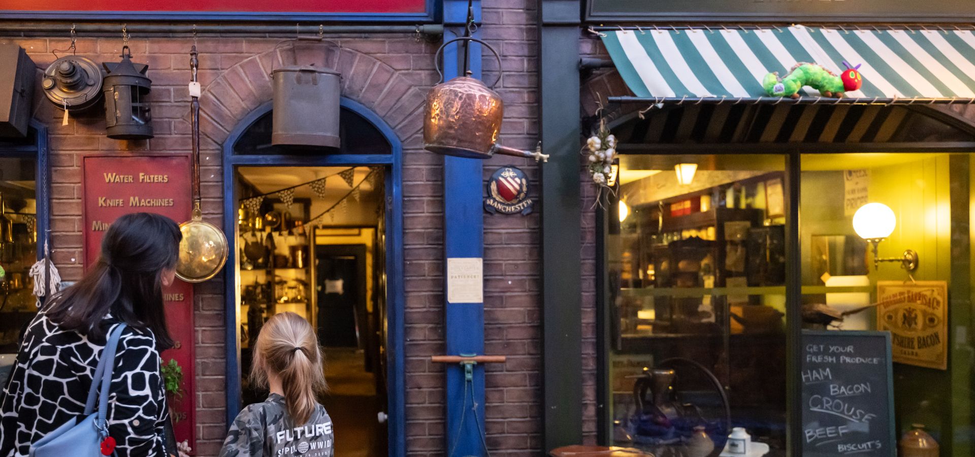 An adult and child looking trough a walkway in victorian streets