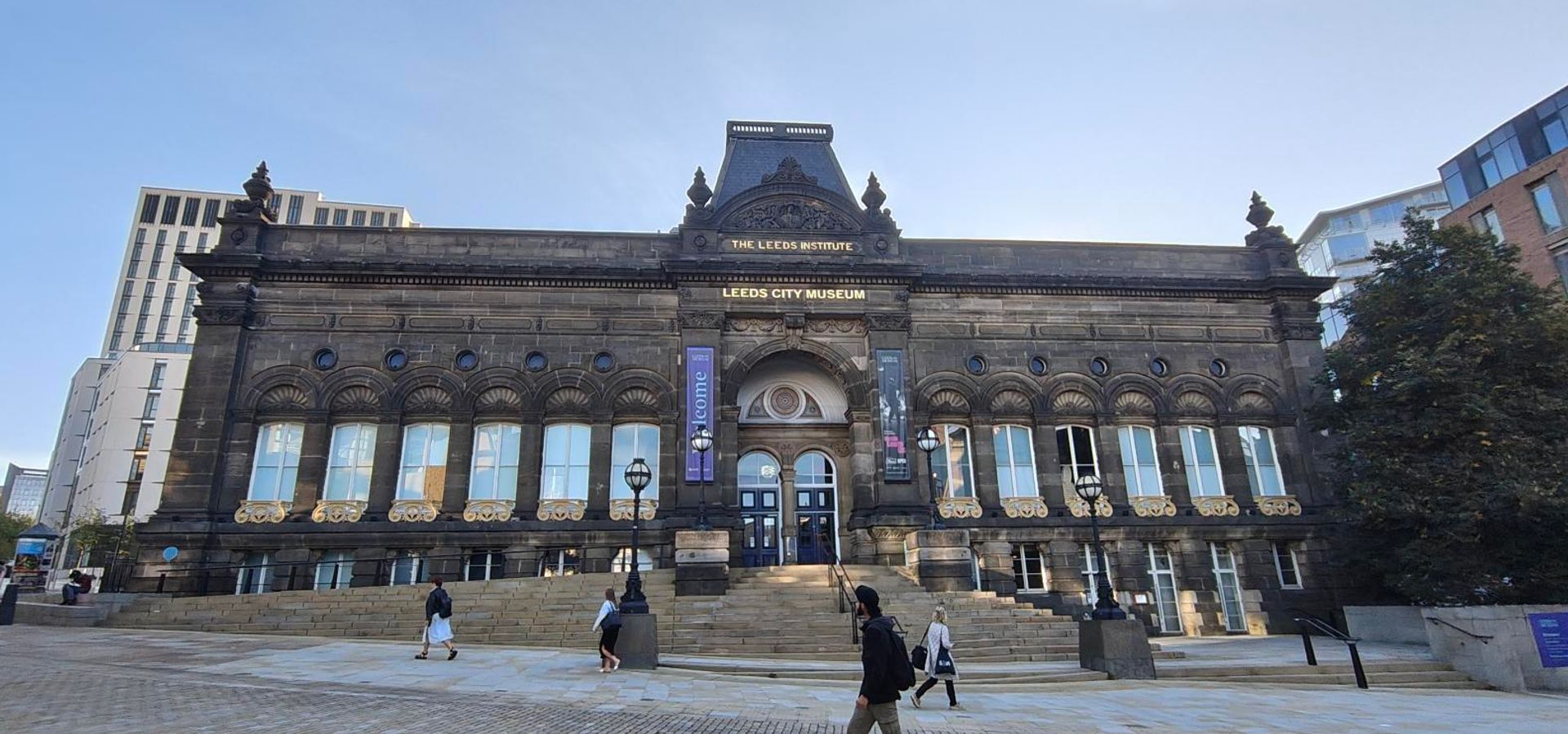 The front façade of Leeds City Museum with the sun rising behind