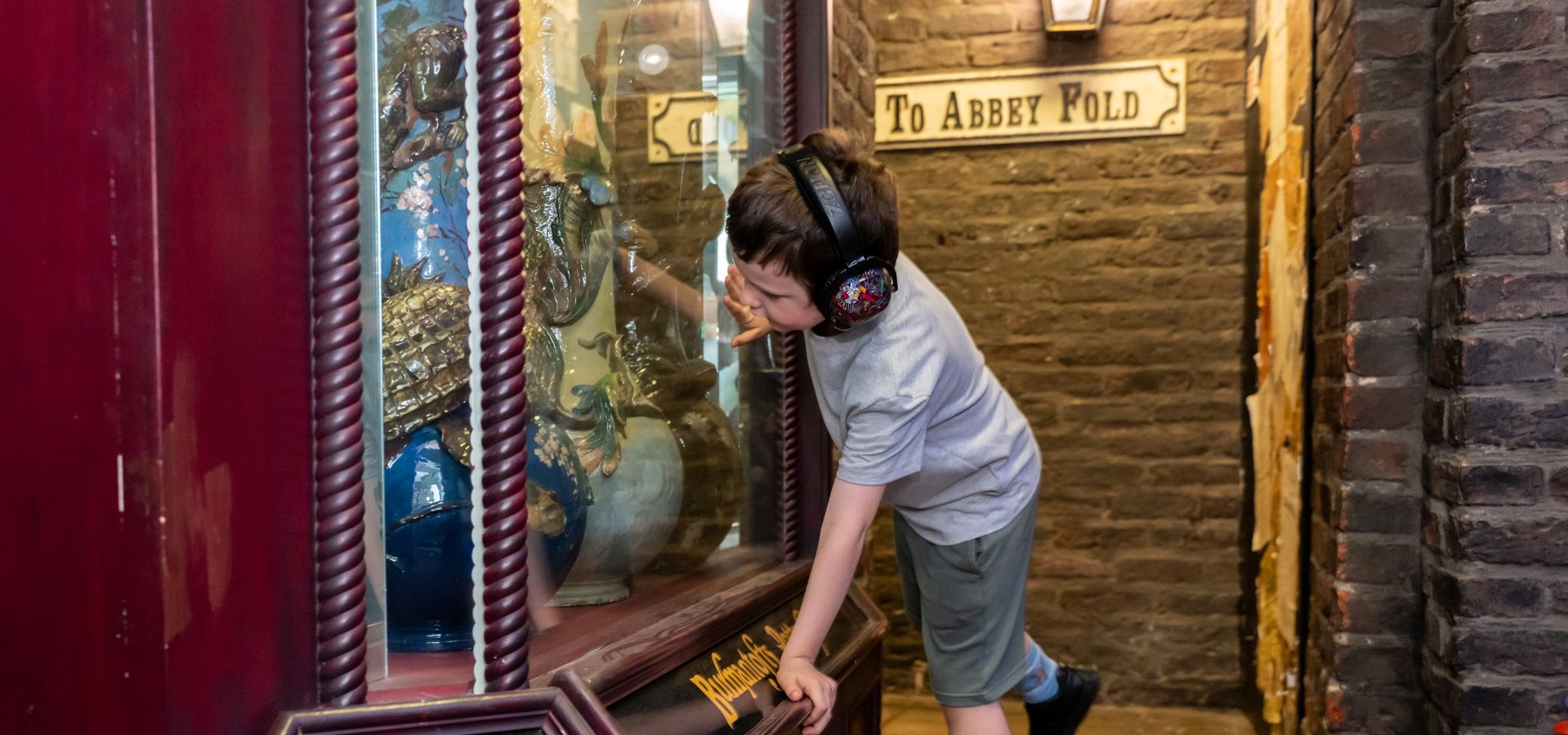 A child looking at pottery in a vicotrian shop window