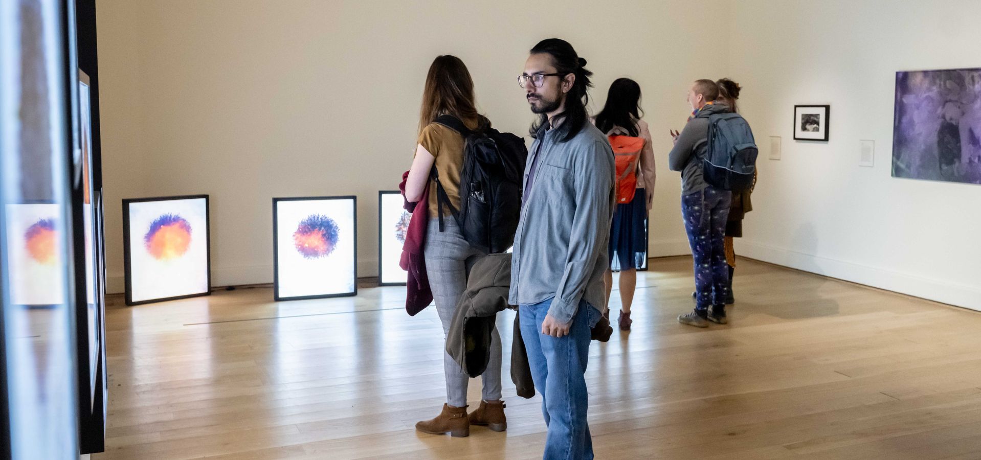 A group pf adults looking at artwork in a gallery