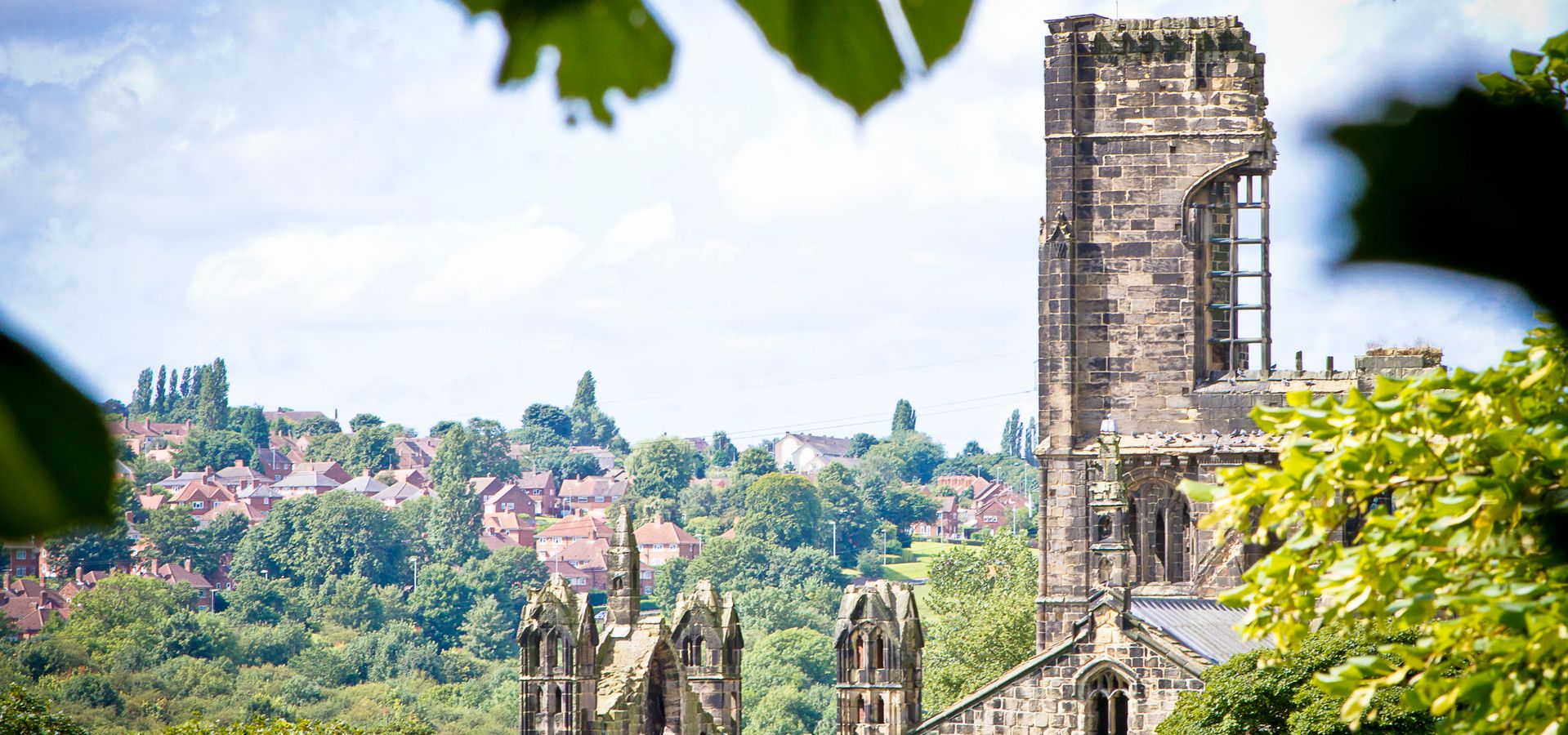 The top of Kirkstall Abbey peaking through trees