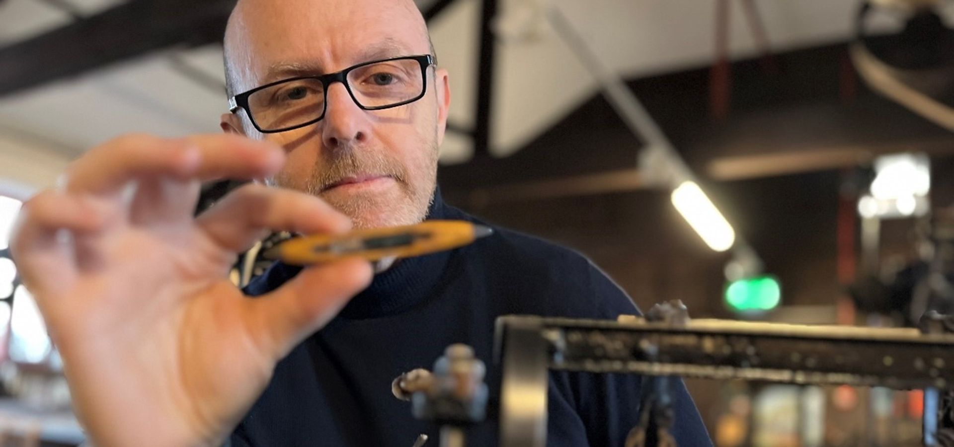 Man holding tiny loom