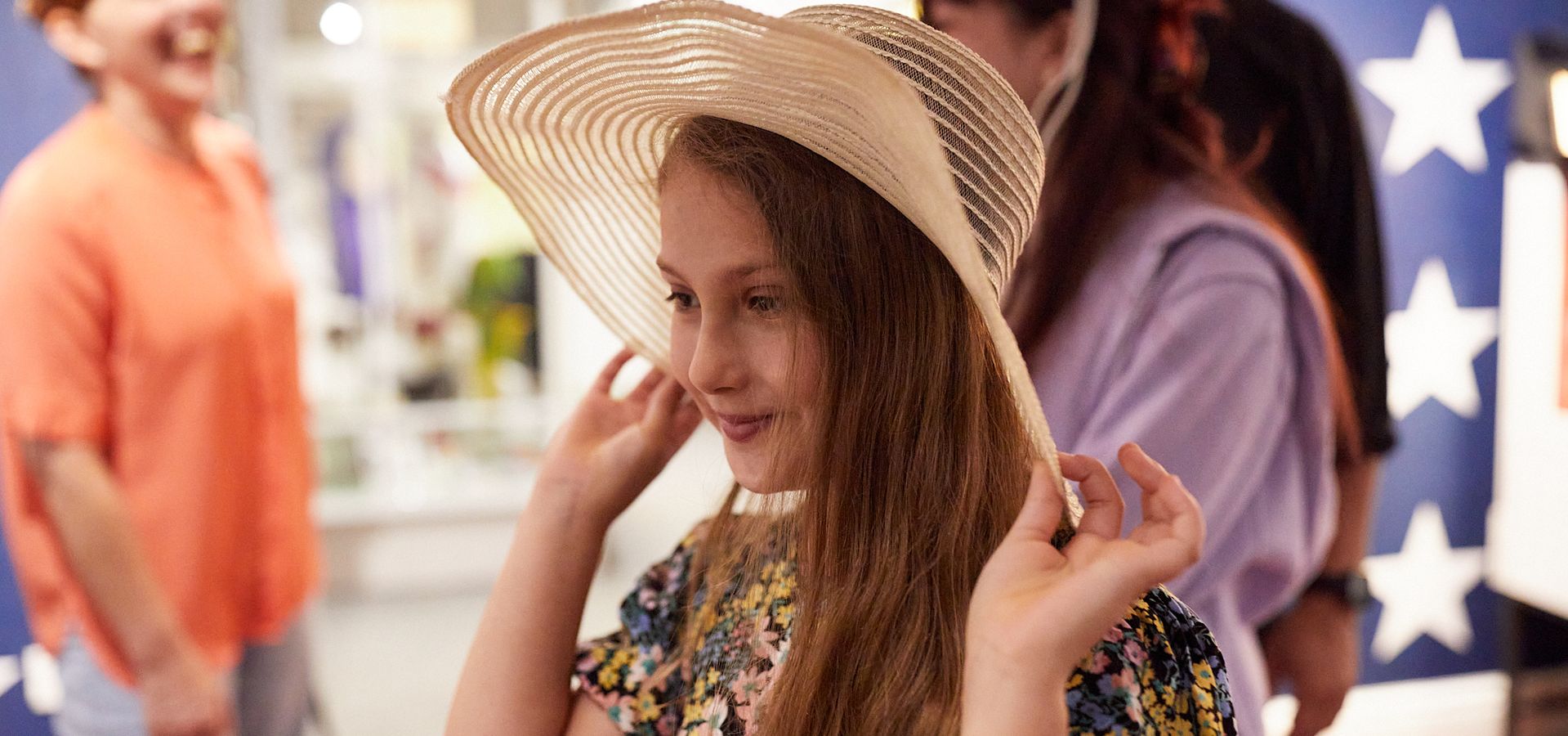 Two girls trying on old fashioned hats in the Museum